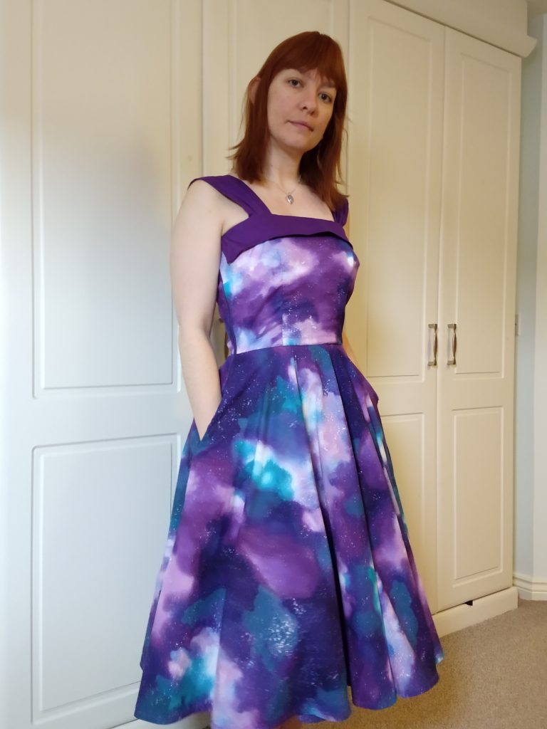 front view of michelle modelling the galaxy dress with her hands in the pockets