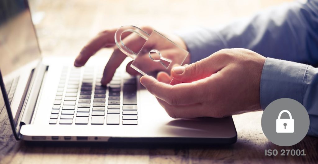 a man holding a transparent plastic lock in one hand while typing on a laptop with the other