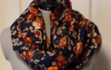 a navy blue snoody buff with an orange flower pattern