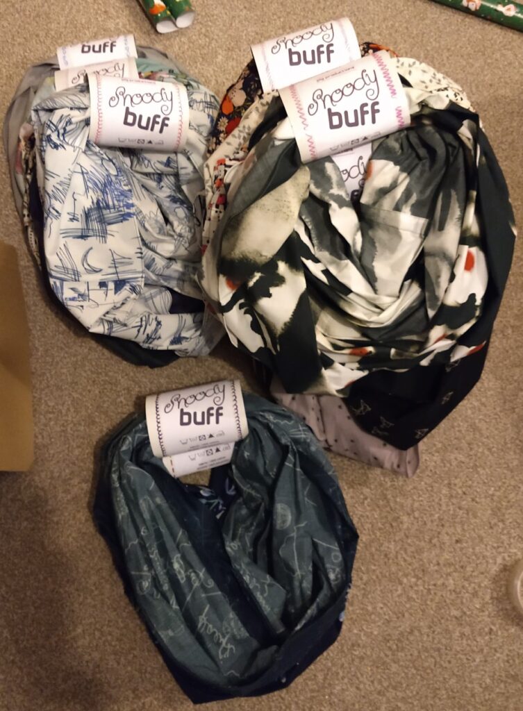 several snoods in three different piles with carboard tube labels around each of them